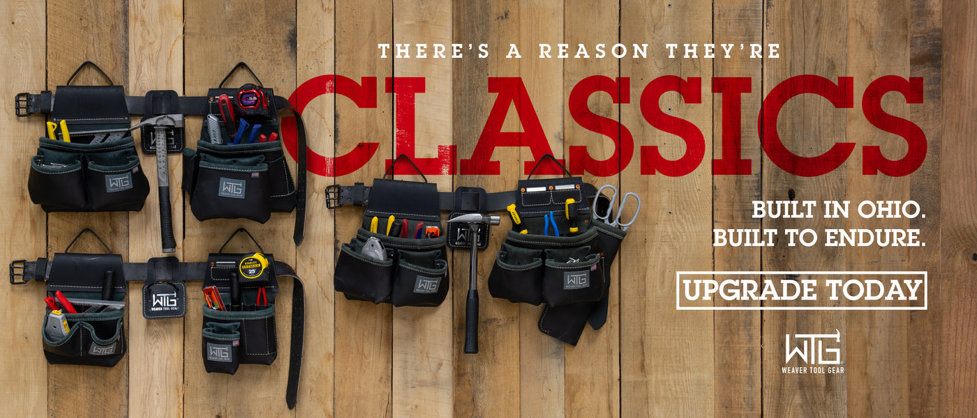 Assortment of black leather tool belts and pouches filled with hand tools, hammers, measuring tape, scissors, and pliers displayed on a rustic wooden plank background.